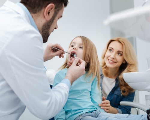 Mother observing during children's dental checkup and teeth cleaning visit