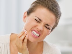 Woman with toothache holding cheek