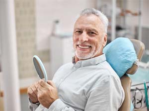 senior man in dental chair smiling