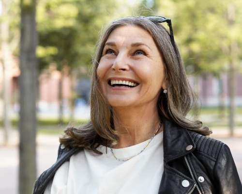 Woman smiling after dental implant tooth replacement