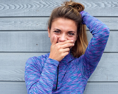 woman covering smile before Invisalign in New City