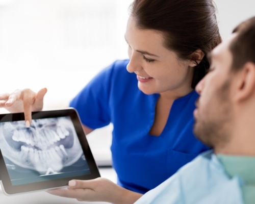 Dentist and patient looking at digital x-rays